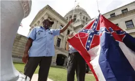  ?? Photograph: Rogelio V Solis/Associated Press ?? Mississipp­i state employees Willie Townsend, left, and Joe Brown raise the state flag over the Capitol grounds.