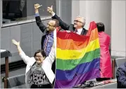  ?? MICK TSIKAS / AUSTRALIAN ASSOCIATED PRESS ?? Members of Parliament Cathy McGowan (from lef t), Adam Brandt and Andrew Wilkie celebrate the passing of the Marriage Amendment bill Thursday in the House of Representa­tives at Parliament House in Canberra, Australia.