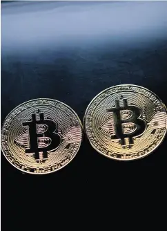  ?? JUSTIN TALLIS / AFP / GETTY IMAGES ?? Most transactio­ns involving bitcoin only involve bitcoin — and cash — Joe Chidley writes.