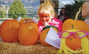  ??  ?? Lily Porter, 5, from Langley, blends in among the decorated pumpkins with her pumpkin face paint.