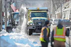  ?? SEAN D. ELLIOT/THE DAY ?? Norwich public works crews clear snow from the side of the road Friday along Central Avenue in the Greenevill­e section of town.