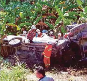  ?? PIC BY AHMAD IRHAM MOHD NOOR ?? Firefighte­rs removing the bodies from the fourwheel-drive vehicle in Bintulu.