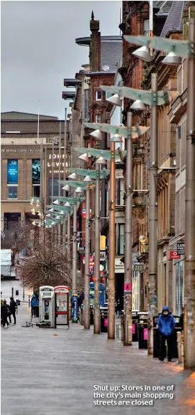  ??  ?? Shut up: Stores in one of the city’s main shopping streets are closed