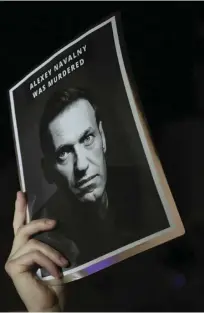  ?? KEVIN DIETSCH/GETTY IMAGES/GENCE FRANCE-PRESSE ?? POSTER with Alexei Navalny’s face is held by a protester during a rally at the Russian Embassy in Washington, DC. following his death.