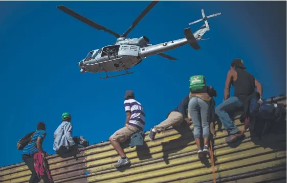  ?? Picture: AFP ?? Migrants climb the border fence between Mexico and the US, leading to arrests (inset) near the El Chaparral border crossing, in Tijuana.