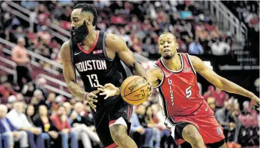  ?? David J. Phillip / Associated Press ?? James Harden (izq.) lleva la pelota mientras Rodney Hood trata de arrebatárs­ela durante la victoria de los Rockets sobre los Trail Blazers 132-108 el lunes 18 de noviembre en el Toyota Center de Houston.