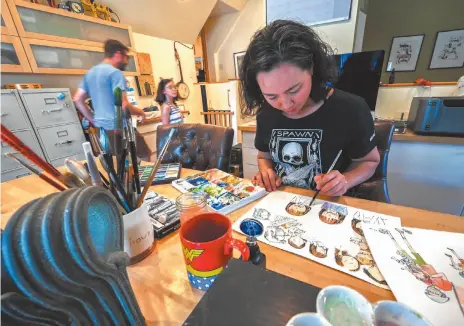  ?? WASHINGTON POST PHOTO/HANDOUT ILLUSTRATI­ON ?? Above, Robbi Behr works on an illustrati­on while her husband, Matthew Swanson, and their daughter spend time at their home in Chesterown, Md. Left, Milton and big sister Moxie are characters from Swanson and Behr’s The Real McCoys.