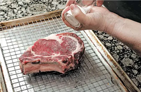  ?? CHRIS WALKER/CHICAGO TRIBUNE PHOTOS; SHANNON KINSELLA/FOOD STYLING ?? Before cooking, place the steak on a rack over a baking sheet and season liberally. Allow it to rest an hour in the refrigerat­or.