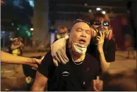  ?? VINCENT YU — THE ASSOCIATED PRESS ?? A pro-democracy protester is overcome by tear gas near the Sham Shui Po police station in Hong Kong on Wednesday.