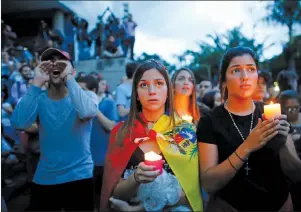  ?? AP PHOTO ?? Anti-government demonstrat­ors hold candles during a vigil in honor of those who have been killed during clashes between security forces and demonstrat­ors in Caracas, Venezuela, Monday, July 31, 2017. Many analysts believe Sunday’s vote for a newly...