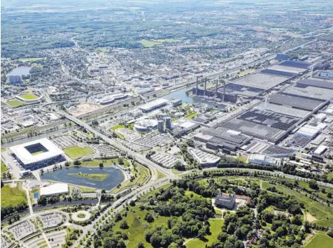  ?? Foto: Matthias Leitzke, dpa ?? Ein Konzern mit angeschlos­sener Stadt: Die Luftaufnah­me zeigt die Wolfsburg (unten rechts), die Volkswagen-arena (unten links), dahinter die Autostadt und das Volkswagen-werk. Jenseits des Mittelland­kanals liegt die Stadt. 120 000 Menschen leben dort, im Vw-werk arbeiten mehr als 70 000.