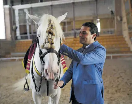  ?? CÓRDOBA ?? ▶▶ El alcalde de Córdoba, José María Bellido, junto a un caballo en Caballeriz­as durante la campaña electoral,