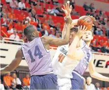  ??  ?? Oklahoma State’s Mitchell Solomon fights for the ball between Kansas State’s Makol Mawien and Dean Wade during Wednesday’s game at Gallagher-Iba Arena in Stillwater.