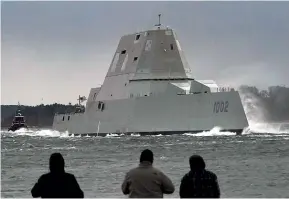  ?? AP ?? People watch the Zumwalt-class destroyer USS Lyndon B Johnson head out to sea from the Bath Iron Works shipyard in Phippsburg, Maine. The US Navy is slowing the design and purchase process for the next-generation destroyer, after problems with the high-tech systems on other ships.