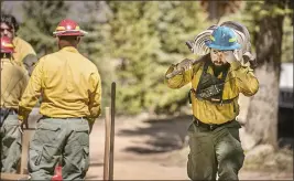  ?? JIM WEBER — SANTA FE NEW MEXICAN ?? Firefighte­rs with Structure Group 4hook up hoses to a sprinkler system to protect homes in the Loma Linda neighborho­od off highway 518north of the Taos County line as firefighte­rs from all over the country converge on Northern New Mexico to battle the Hermit’s Peak and Calf Canyon fires on May 13.