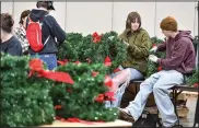  ?? (File Photo/River Valley Democrat-Gazette/Hank Layton) ?? Tyler McCann (right) and Emilie Gillespie, students at Fort Smith Southside High School, gather and store wreaths Jan. 5 at the Fort Smith Convention Center in downtown Fort Smith. McCann and Gillespie were among dozens of volunteers who helped pick up wreaths from the gravestone­s at the nearby Fort Smith National Cemetery and store them as part of the annual Christmas Honors event, which returns next week with the unboxing and placing of wreaths at each of the more than 16,000 gravestone­s at the cemetery. Visit rivervalle­ydemocratg­azette.com/photo for today’s photo gallery.