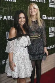  ?? Photos and text from wire services ?? Demi Lovato, left, and Kate Hudson arrive at the launch of Demi Lovato and Fabletics Collaborat­ion Collection Wednesday in Beverly Hills, Calif.