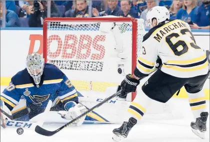  ?? JEFF ROBERSON/AP ?? Bruins left wing Brad Marchand reaches for a rebound in front of Blues goaltender Jordan Binnington in the first period of Game 6 on Sunday in St. Louis.