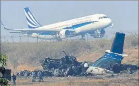  ?? AFP ?? ▪ An airplane takes off near the wreckage of the USBangla Airlines plane that crashed on Monday.