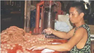  ?? JOSELITO VILLASIS/PN ?? A man prepares chorizo at the Iloilo Central Market. Starting next year, the City Health Office will require all food handlers to undergo training.