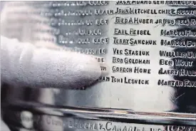  ?? CHARLES KRUPA THE ASSOCIATED PRESS ?? The National Hockey League’s Mike Bolt, who is a keeper of the Stanley Cup when it travels, points out Gordie Howe’s name on the team engraving of the 1954-55 Detroit Red Wings.