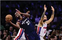  ?? DERIK HAMILTON — THE ASSOCIATED PRESS ?? The Sixers’ Joel Embiid, left, drives to the basket past Detroit Pistons’ Evan Fournier and James Wiseman during the second half of Tuesday night’s win.