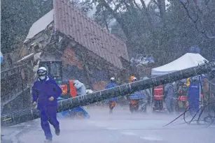  ?? THE ASSOCIATED PRESS ?? Rescuers halt a search operation due to strong rain Saturday at the site of a landslide in Anamizu town, Ishikawa prefecture. Monday’s temblor decimated houses, twisted and scarred roads, scattered boats like toys in the waters and prompted tsunami warnings.