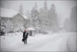  ?? ELIAS FUNEZ — THE UNION VIA AP ?? A pedestrian makes their way along Sutton Way in Grass Valley during Monday’s low snowstorm.