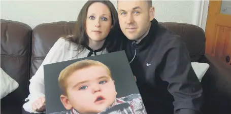  ??  ?? Darren and Janine Fucile with a photo of their late son, Joseph.