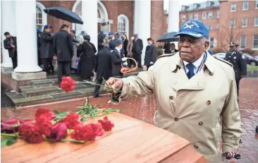  ?? MATT ROURKE / AP ?? Tuskegee Airman Eugene J. Richardson, Jr., places a flower on the casket containing the remains of his comrade John L. Harrison, Jr., after Harrison’s funeral mass at the Chapel of the Four Chaplains in Philadelph­ia, Friday. Harrison Jr. became one of...