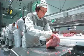  ?? XINHUA ?? Employees of Finnish meat producer Atria, which is based in Seinajoki, western Finland, process pork as per the requiremen­t of Chinese consumers.