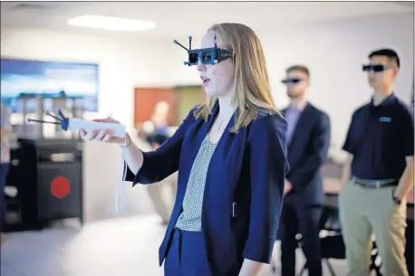  ?? [BRYAN TERRY PHOTOS/ THE OKLAHOMAN] ?? Boeing intern Yana Tatgenhors­t on Thursday demonstrat­es the IC. IDO virtual reality system for other interns at Boeing's Oklahoma City office.