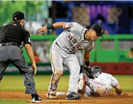  ?? DAVID SANTIAGO / MIAMI HERALD ?? Giants second baseman Joe Panik tags out Marlins right fielder J.B. Shuck, who is caught stealing in the 12th inning at Marlins Park on Thursday.