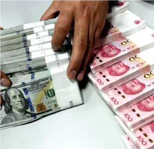  ??  ?? The yuan weakened against the US dollar last year