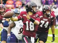  ?? JOHN RAOUX AP ?? Troy quarterbac­k Gunnar Watson (18) looks for a receiver as he is pressured by UTSA defensive lineman Joe Evans.