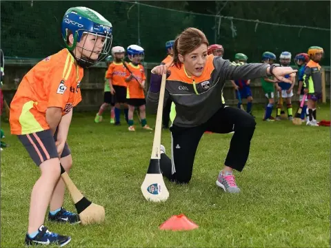  ??  ?? Kate Kelly passing on some tips at a Cúl Camp in Killurin in 2017. She is happy that the new rules will allow her beloved camogie to flow.