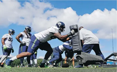  ?? PHOTOS: TED S. WARREN/THE ASSOCIATED PRESS ?? Seattle Seahawks defensive end Shaneil Jenkins hits a blocking sled in the first day of the team’s football training camp, Sunday, in Renton, Wash. A couple of veteran players were unable to practice, including Tyler Lockett and DeShawn Shead.