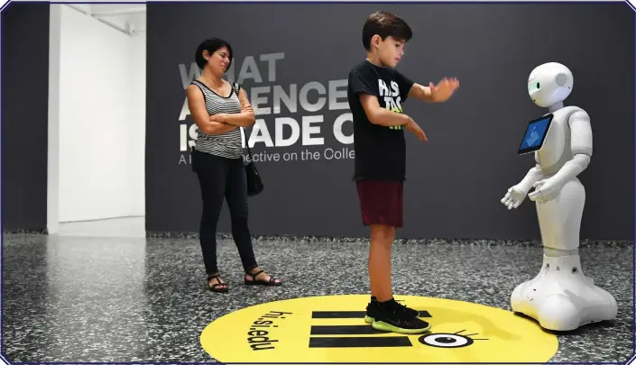  ?? PICTURE: WASHINGTON POST ?? Emilia Labrada watches her son, Julian Allan, 12, interact with Pepper, a human-like robot at the Smithsonia­n’s Hirshhorn Museum.