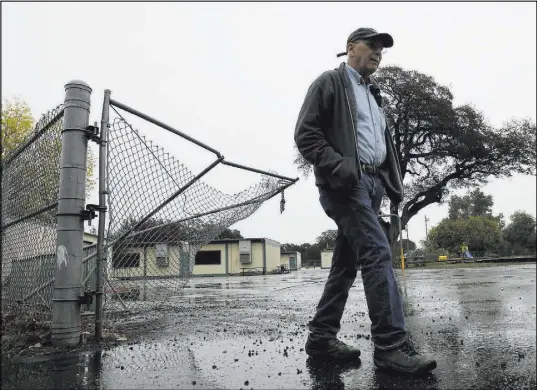  ?? Rich Pedroncell­i The Associated Press ?? Randy Morehouse, the maintenanc­e and operations supervisor for the Corning Elementary School District, walks Wednesday past the gate at the Rancho Tehama Elementary School that gunman Kevin Janson Neal crashed through during his shooting rampage.