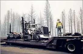  ?? NOAH BERGER/AP ?? A truck that was trapped by a racing wildfire and incinerate­d in Shasta-Trinity National Forest near Shasta Lake is set to be towed Thursday. The driver escaped unharmed. Authoritie­s closed 45 miles of Interstate 5 in Northern California.