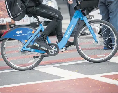  ?? NICOLAUS CZARNECKI / BOSTON HERALD ?? PEDAL PUSHER: A rider uses a rental Bluebike in Roslindale last week. A new $2.5 million grant will be used on several carbon-reducing efforts, including improving biking infrastruc­ture.