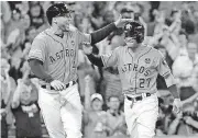  ?? [AP PHOTO] ?? Houston Astros’ George Springer (4) and Jose Altuve (27) celebrate after they scored on teammate Carlos Correa’s double in Game 2 of baseball’s American League Division Series against the Boston Red Sox on Friday in Houston, Texas.