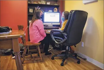  ?? Paul Buckowski / Times Union ?? Devon Tarella sits with her daughter, Calogera Rose, 12, at the computer where the sixth-grader spends a good amount of her day during home schooling.