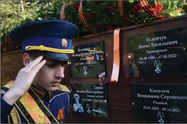  ?? (AP Photo) ?? A military academy cadet salutes Friday in front of plaques with the names of Russian soldiers who have died in Ukraine at a “Hill of Glory” memorial in Yalta, Crimea.