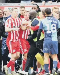  ??  ?? Tempers flare by the dugouts at Wycombe.