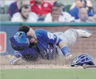  ?? DAVID J. PHILLIP/THE ASSOCIATED PRESS ?? Toronto Blue Jays’ Russell Martin scores on a Troy Tulowitzki triple in a 10-1 blowout of the Texas Rangers in game one of the American League Division Series on Thursday.