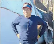  ?? GRAY ROHRER/ORLANDO SENTINEL ?? Devon Griggs stands next to his aunt’s van . The vehicle was crushed by a tree knocked over by Hurricane Michael.