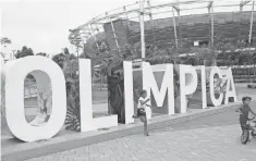  ?? SILVIA IZQUIERDO, AP ?? Children play near the Olympic Park sign in Rio, where many 2016 Summer Games venues are now abandoned.