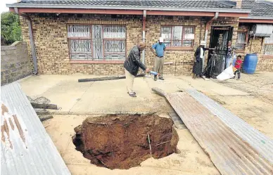  ?? /THULANI MBELE ?? The Ngoako family are living with the danger of a sinkhole in their yard in Ngobi, North West. The sinkhole was discovered by five-year-old Otlotleng two weeks ago.