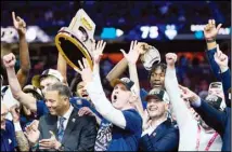  ?? ?? UConn head coach Dan Hurley celebrates with the trophy after their win against Purdue in the NCAA college Final Four championsh­ip basketball game in Glendale, Ariz. (AP)